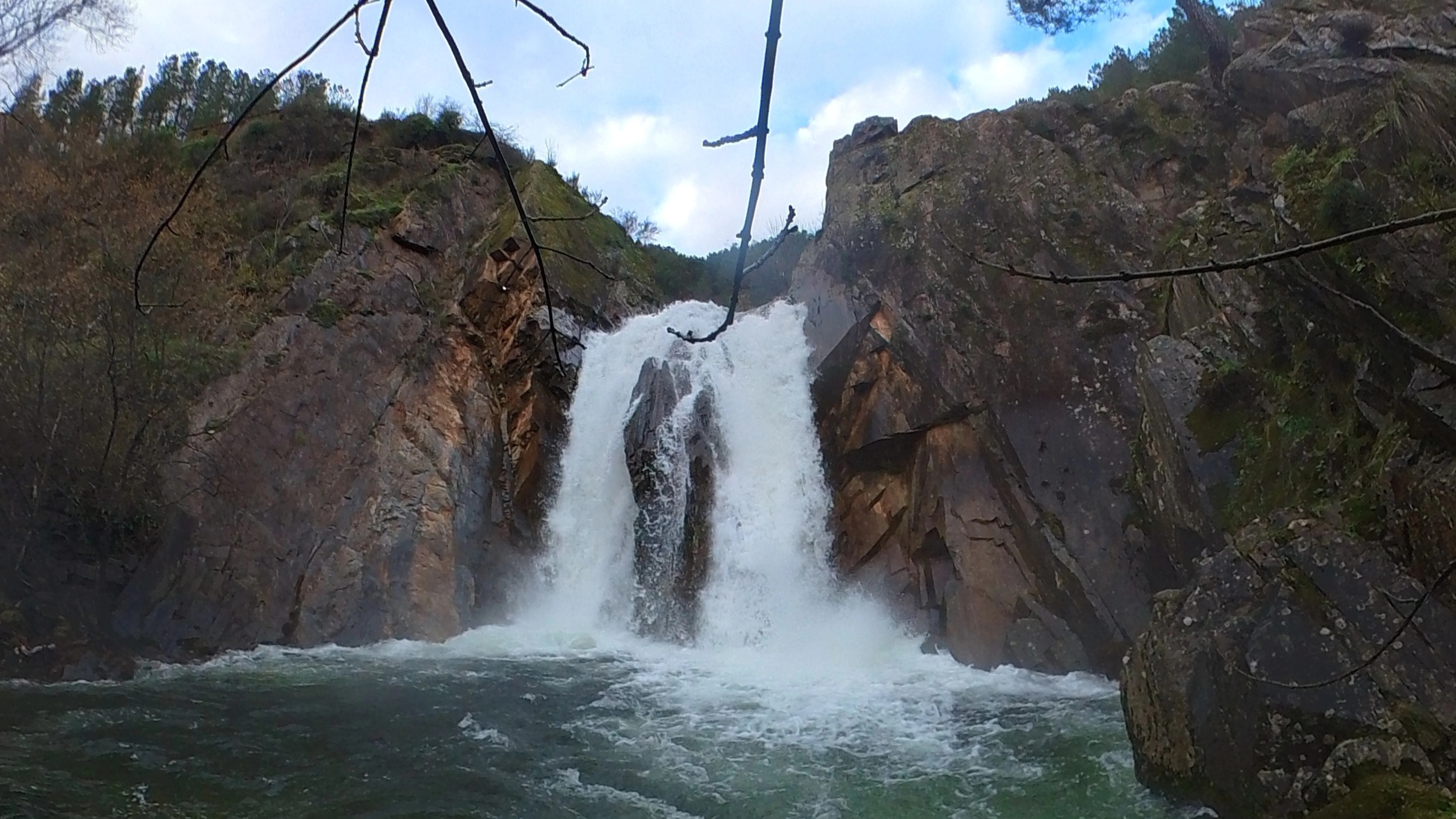 a waterfall roars into a deep pool